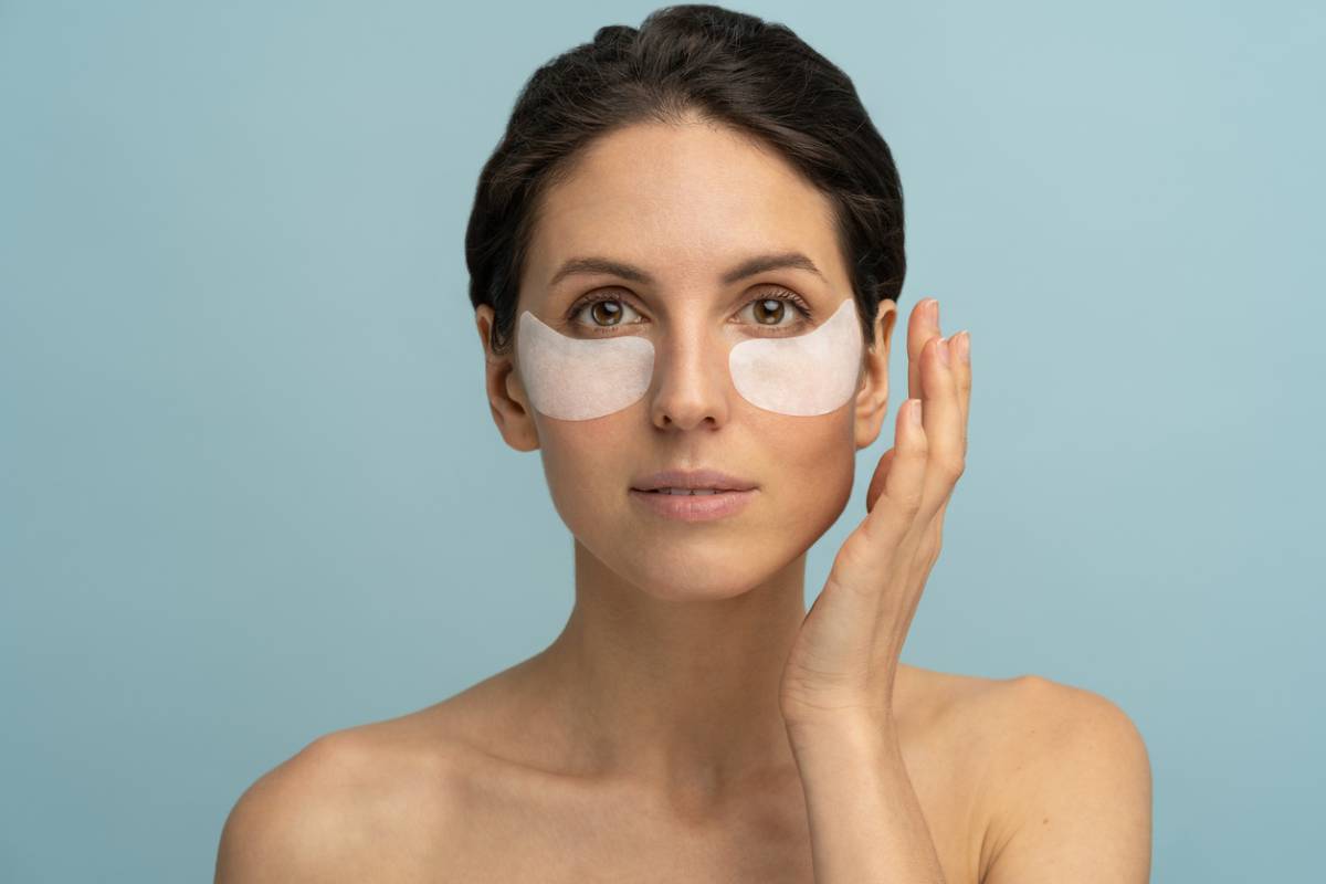 Woman wondering if dark circles are genetic while applying cream.